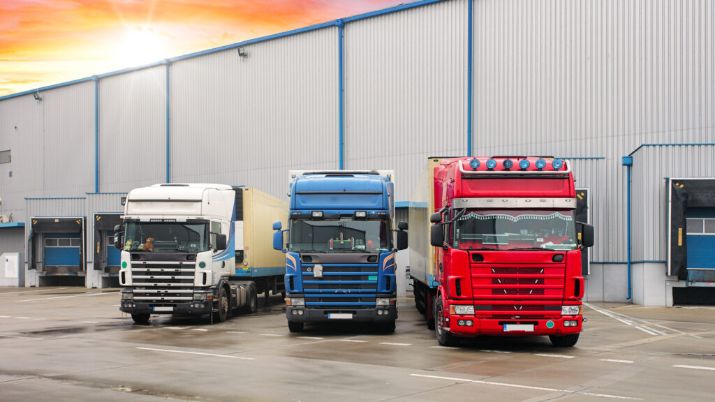 Three trucks in front of a warehouse